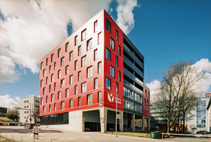 Modern residential building in Tartu Estonia with red façade and concrete structure