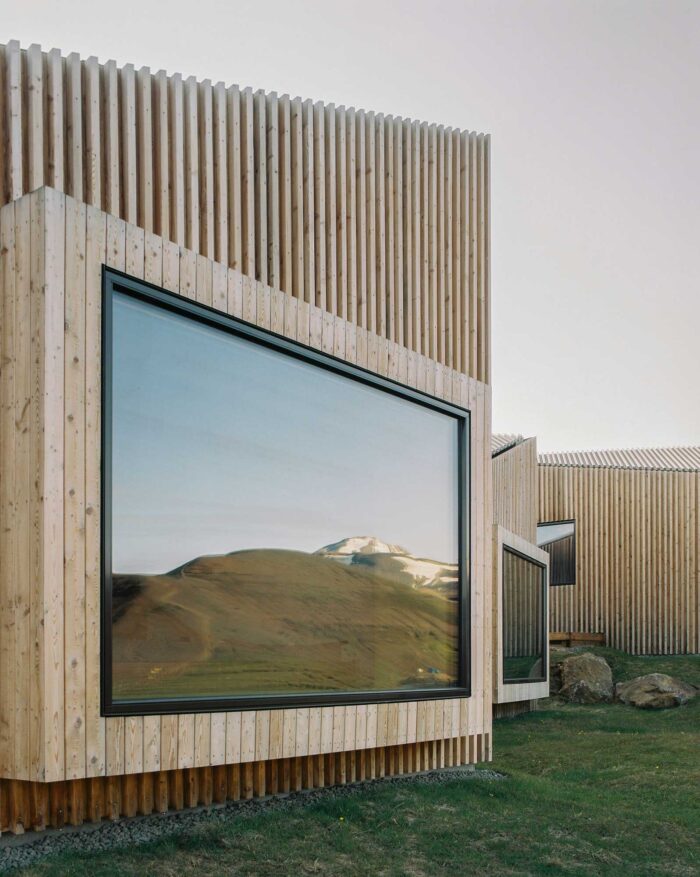 Wooden building with large glass window overlooking the mountains in Iceland