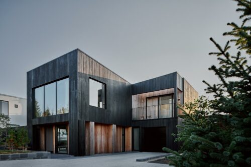 Family home with torched wood and large glass windows