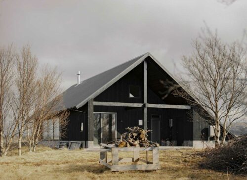 Black house in Iceland with chopped wood laying on a table