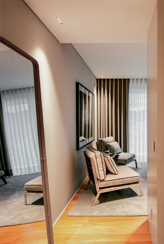 Bedroom with warm colors wooden floors large mirror and grey walls