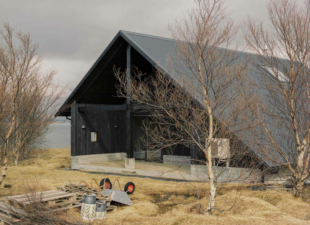 Summer house in South Iceland with long black roof and wooden structure