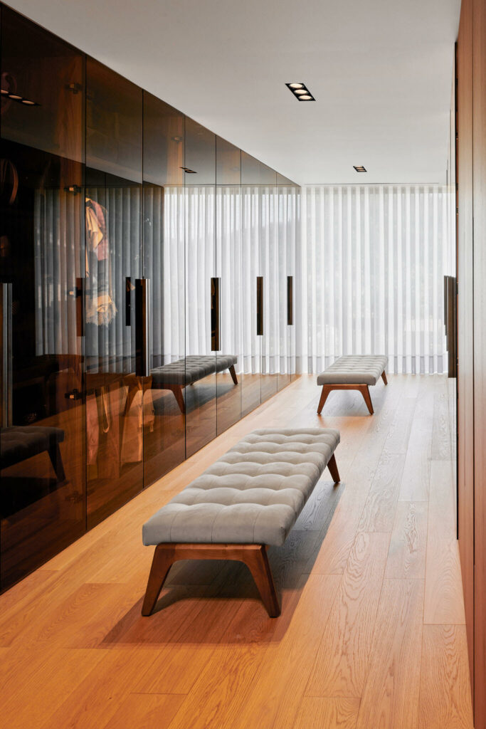 Luxury closet with glass doors and two benches