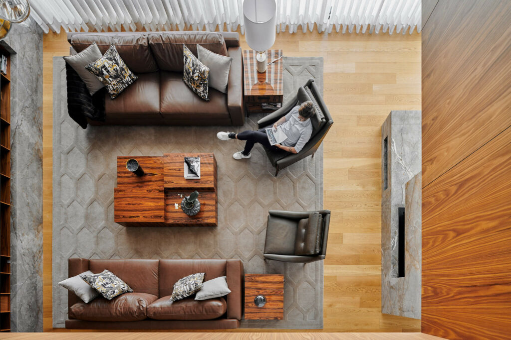 Top view of luxury living room with leather couches and large bright windows