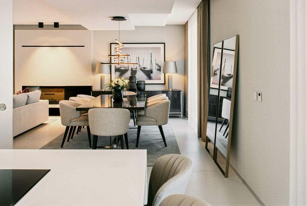 Minimal interior decoration with two lage mirrors grey seats and long dining table