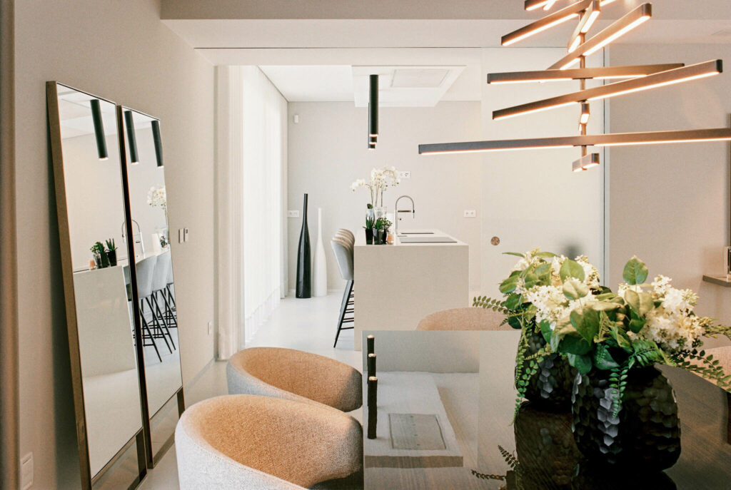 Dining area with contemporary decoration two large mirrors and vase with flowers in top of the table