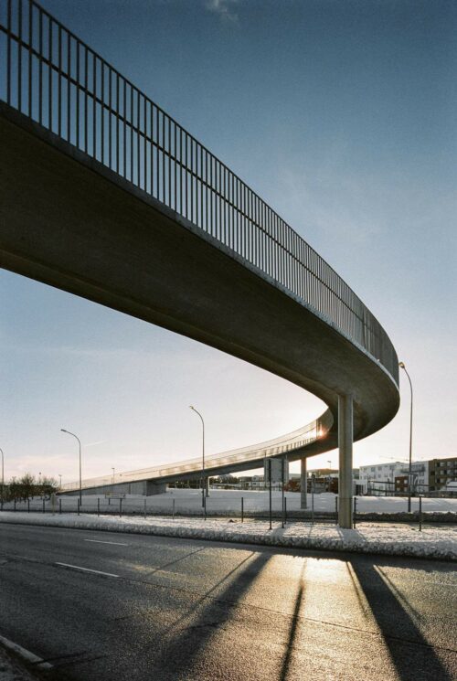 Cicular concrete bridge over road with long shadows casting