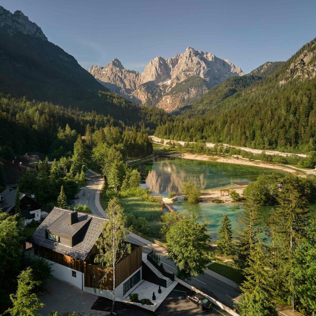 Drone shot of modern building in Kranjska Gora, Slovenia with mountain in the background