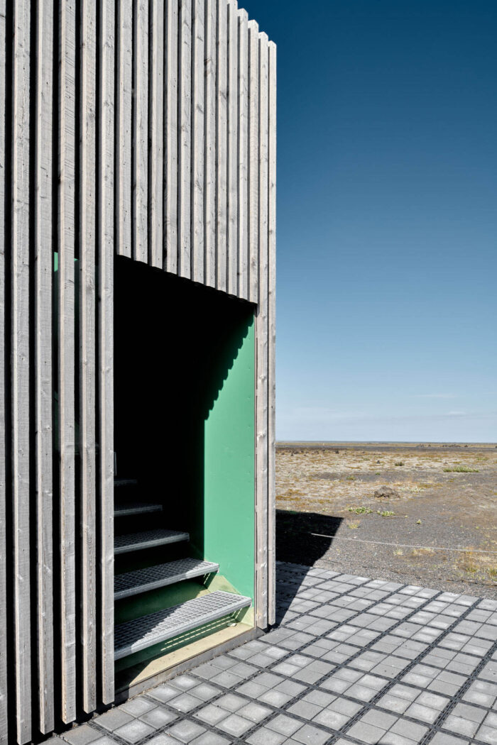 Wooden building with metal staircase and green panels in South Iceland