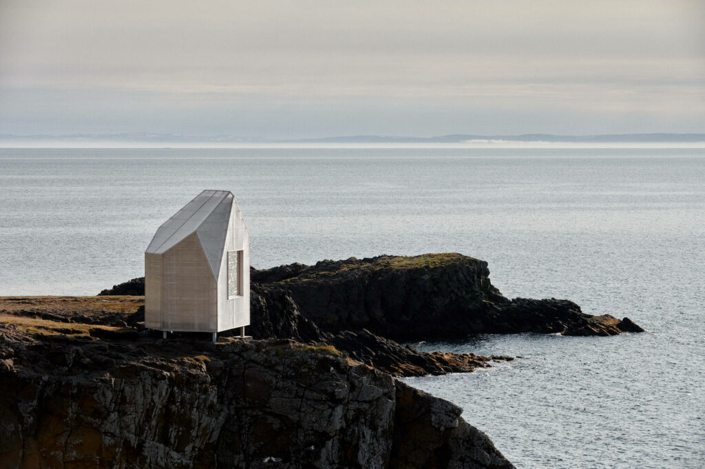 Small cabin at the edge of a cliff overlooking the ocean