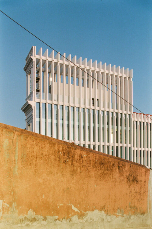 Modern architecture building with white metal cladding façade and decaying concrete wall