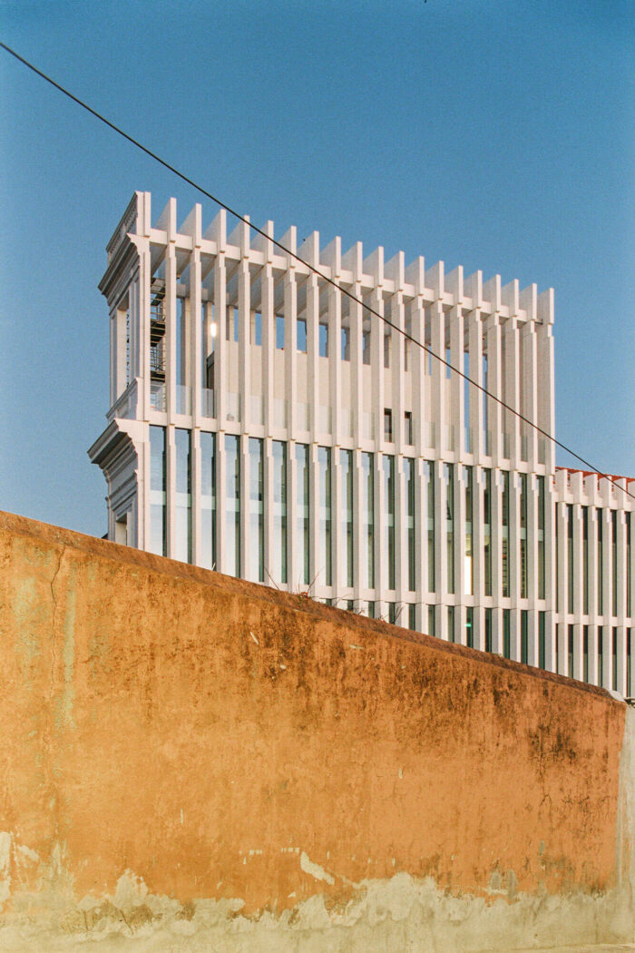 Modern architecture building with white metal cladding façade and decaying concrete wall