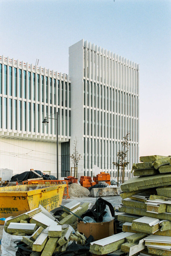 Monder architecture building with insulation materials on the ground and yellow trash container