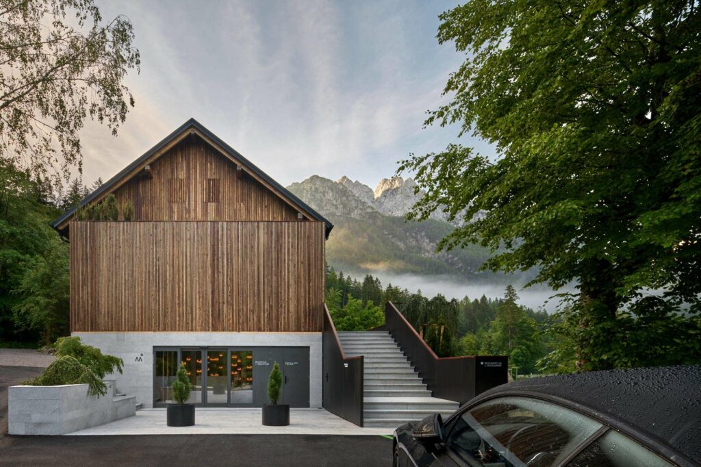 Modern hotel with stone and wooden walls and big mountains in the background