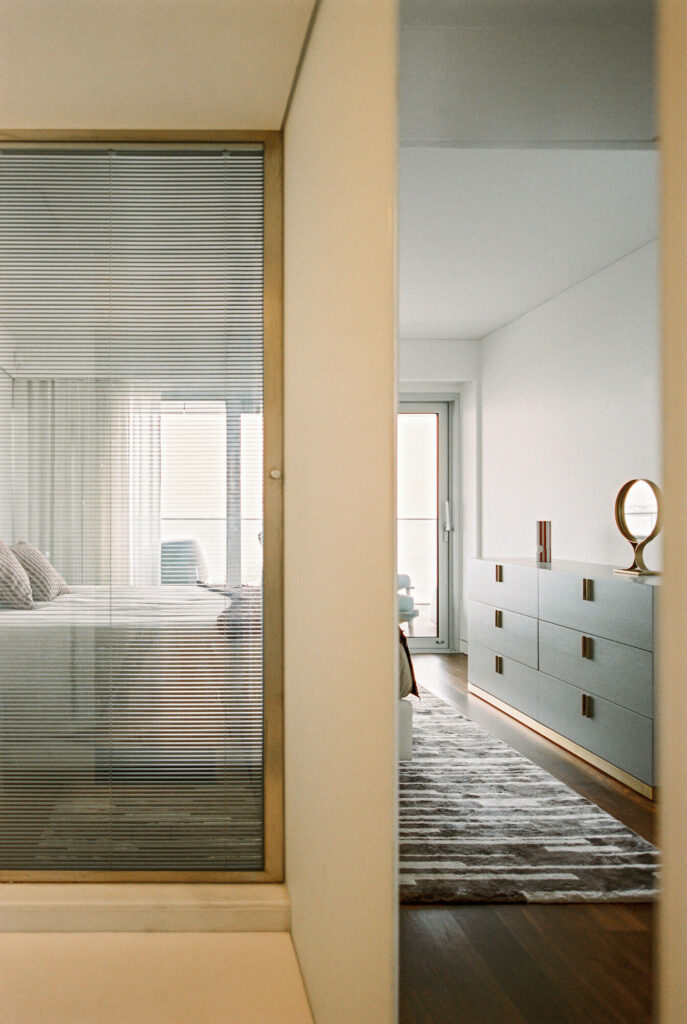 Bedroom entrance with minimal furniture and large bright windows