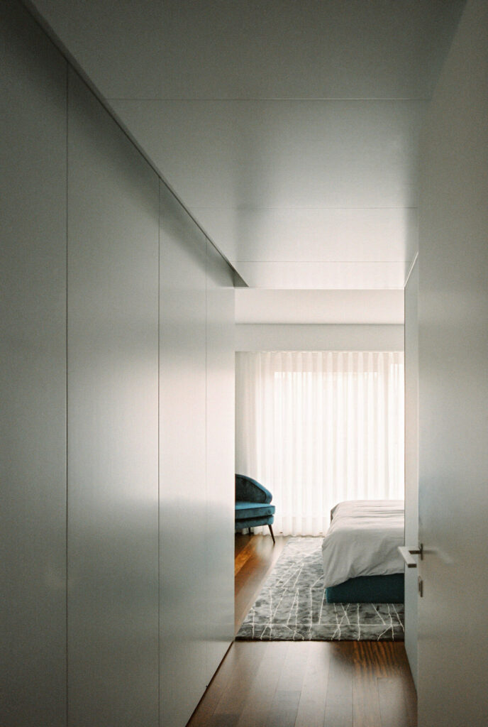 Bedroom hall with white closet doors and large bright windows