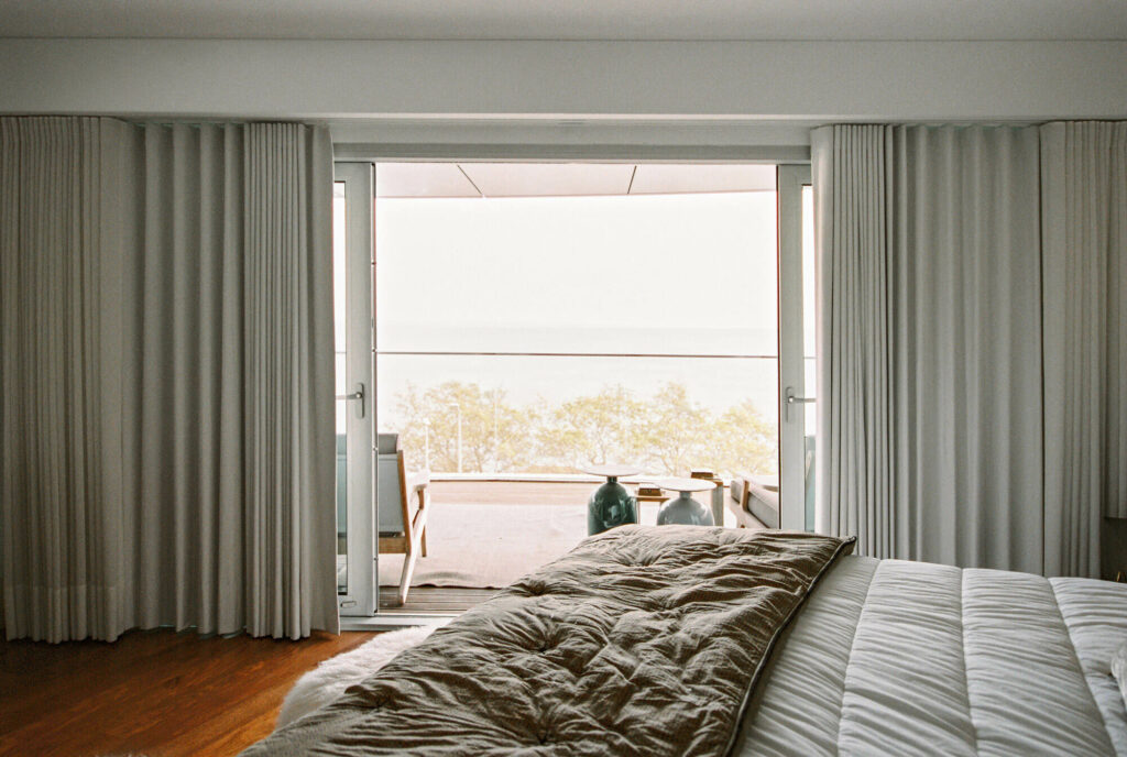 Luxury bedroom with large windows and grey curtains