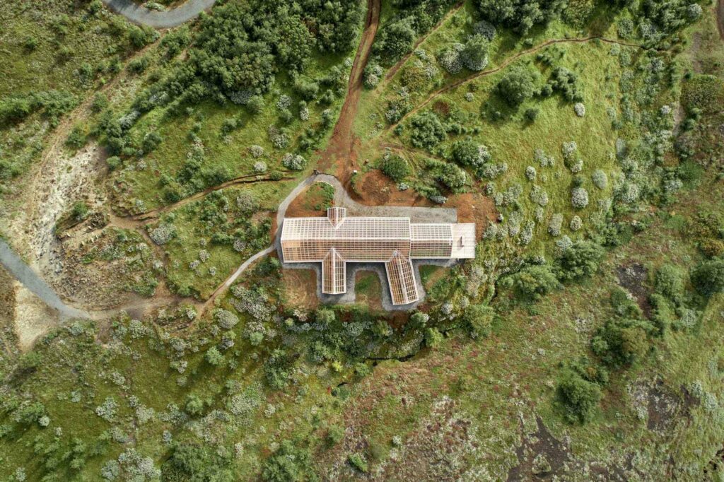 Aerial view of building with plexiglass roof and green vegetation around